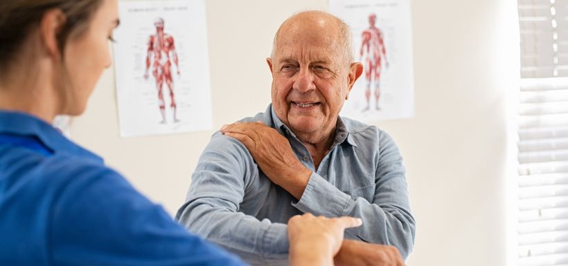 Senior réalisant des exercices d’équilibre avec un kinésithérapeute